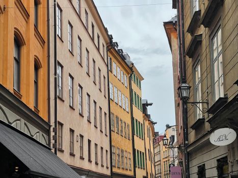 Discover a vibrant street in Stockholm with historic colorful buildings and classic architecture.