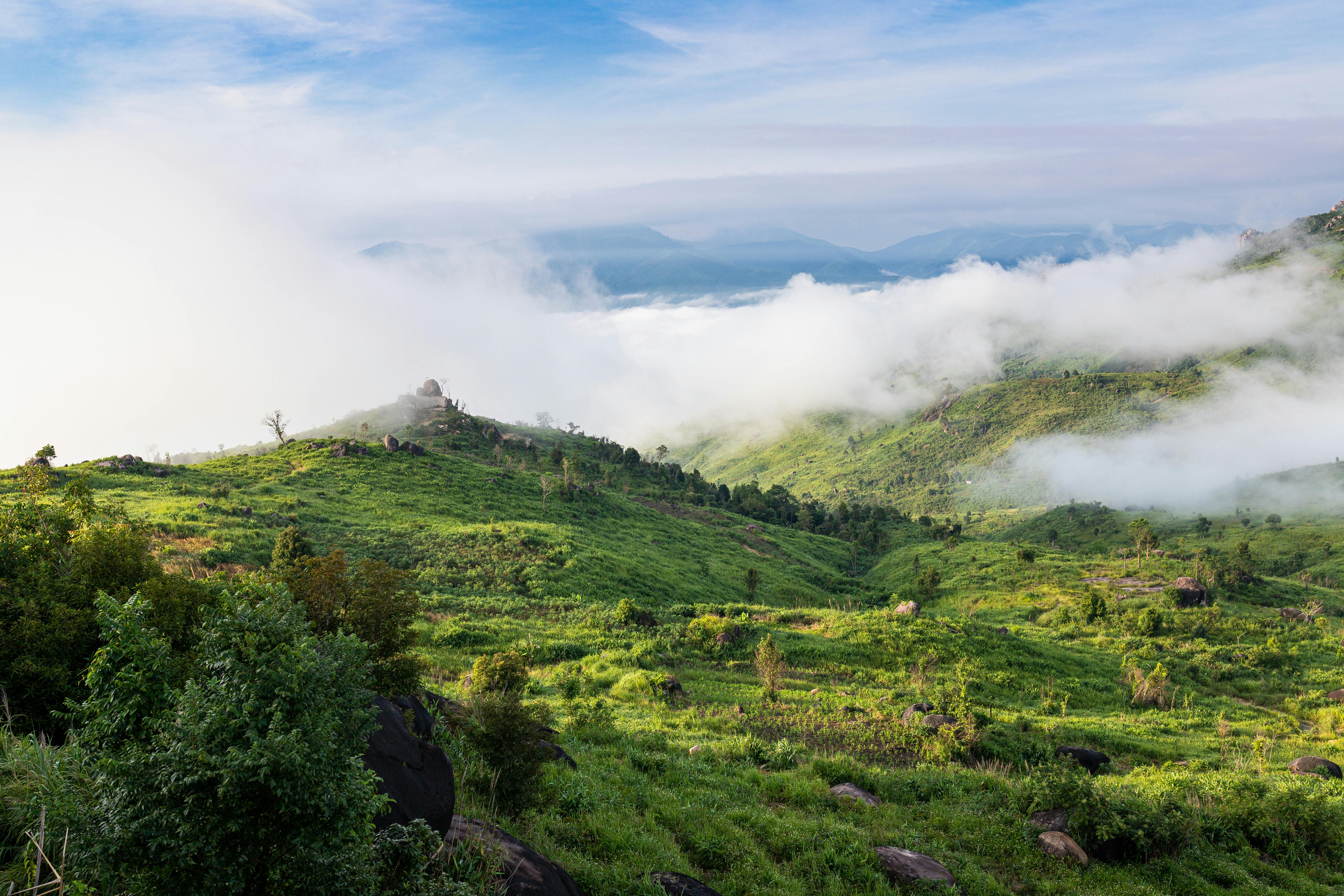 Scenic view of mist-covered green hills in Kon Tum, Vietnam, showcasing natural beauty and tranquility.