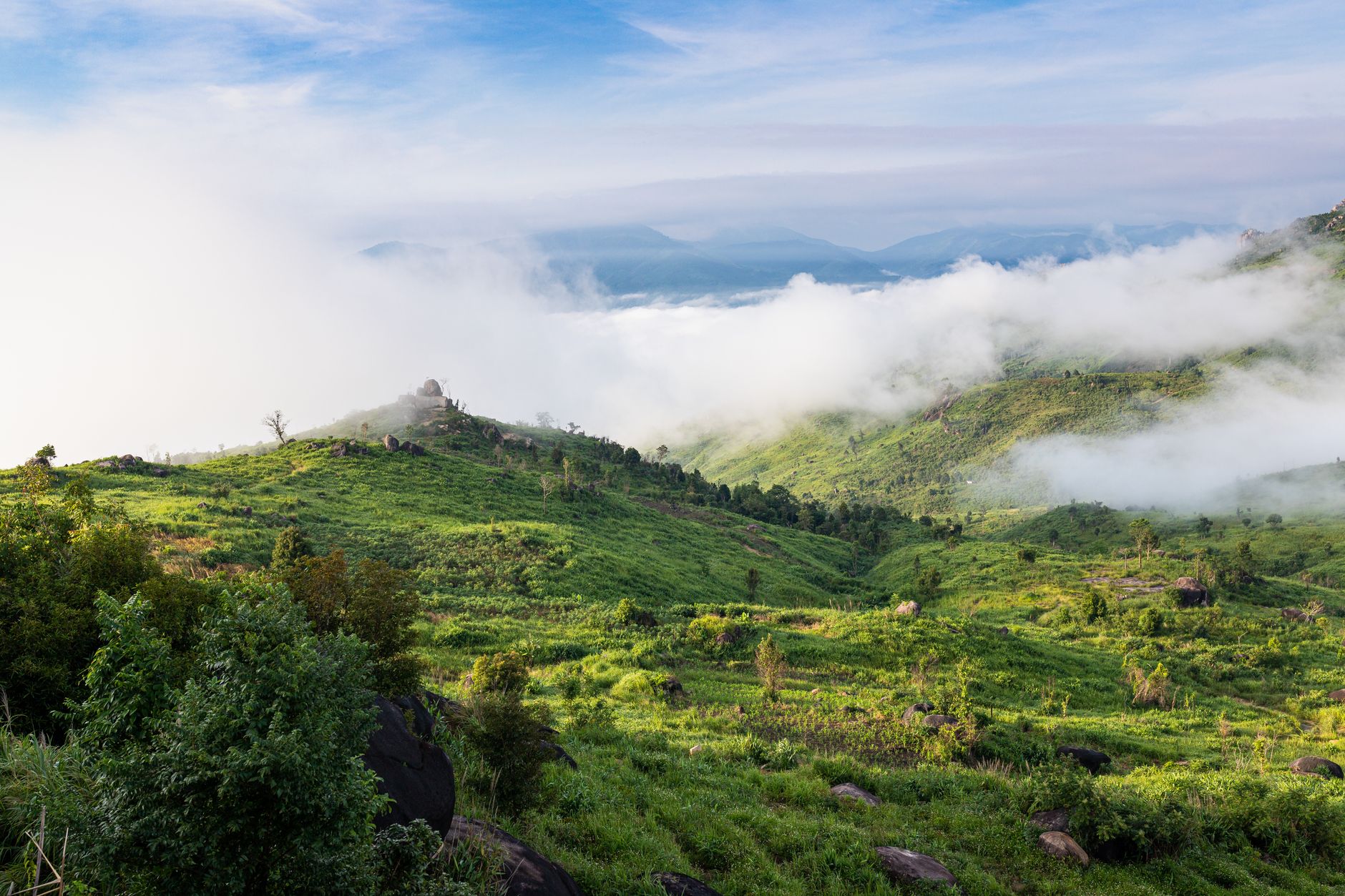 Scenic view of mist-covered green hills in Kon Tum, Vietnam, showcasing natural beauty and tranquility.