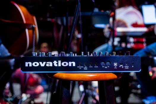 Novation audio device on a stool during a live concert setup, showcasing musical technology.