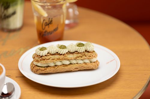 Free A tempting matcha eclair on a white plate at a cozy café setting. Stock Photo