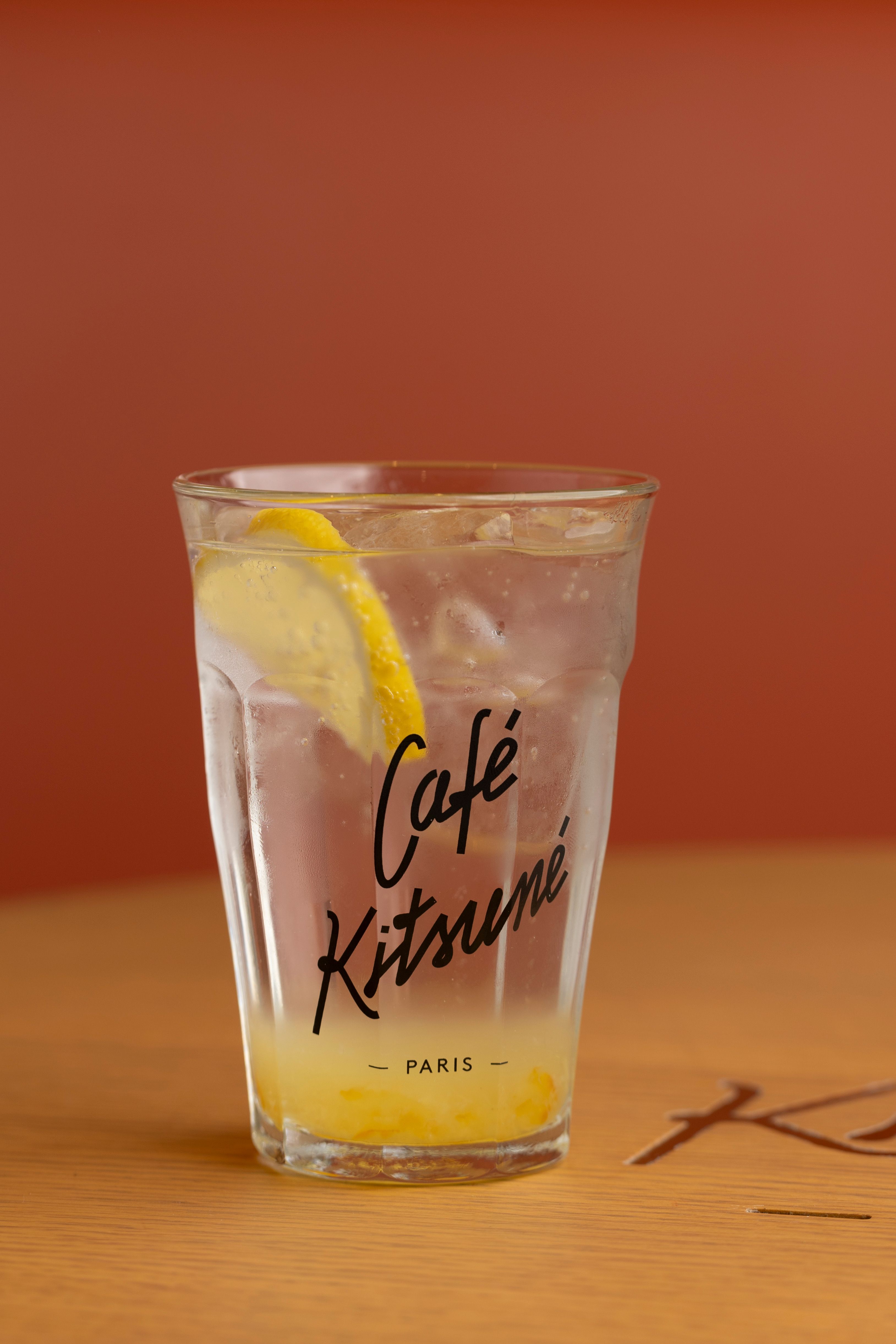 Chilled lemon water in a Café Kitsuné Paris glass with copyspace.