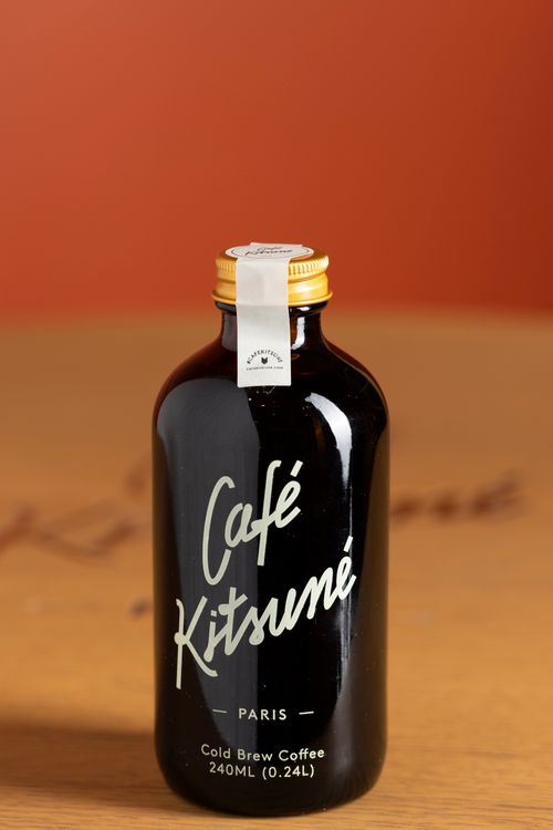 Free Cafe Kitsune glass bottle of cold brew coffee on wood. Stock Photo