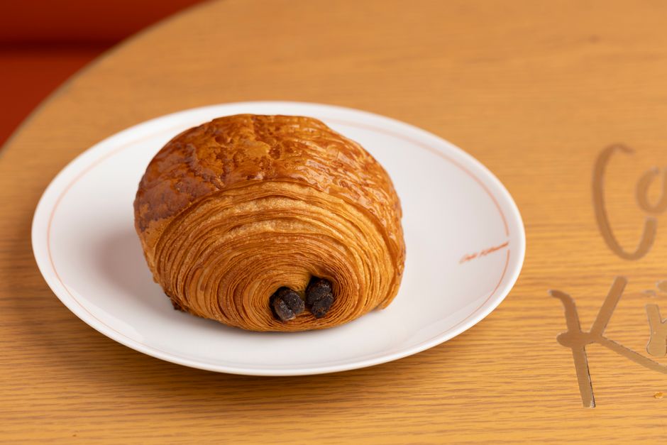Tasty pain au chocolat on a white plate, perfect for breakfast or snack.
