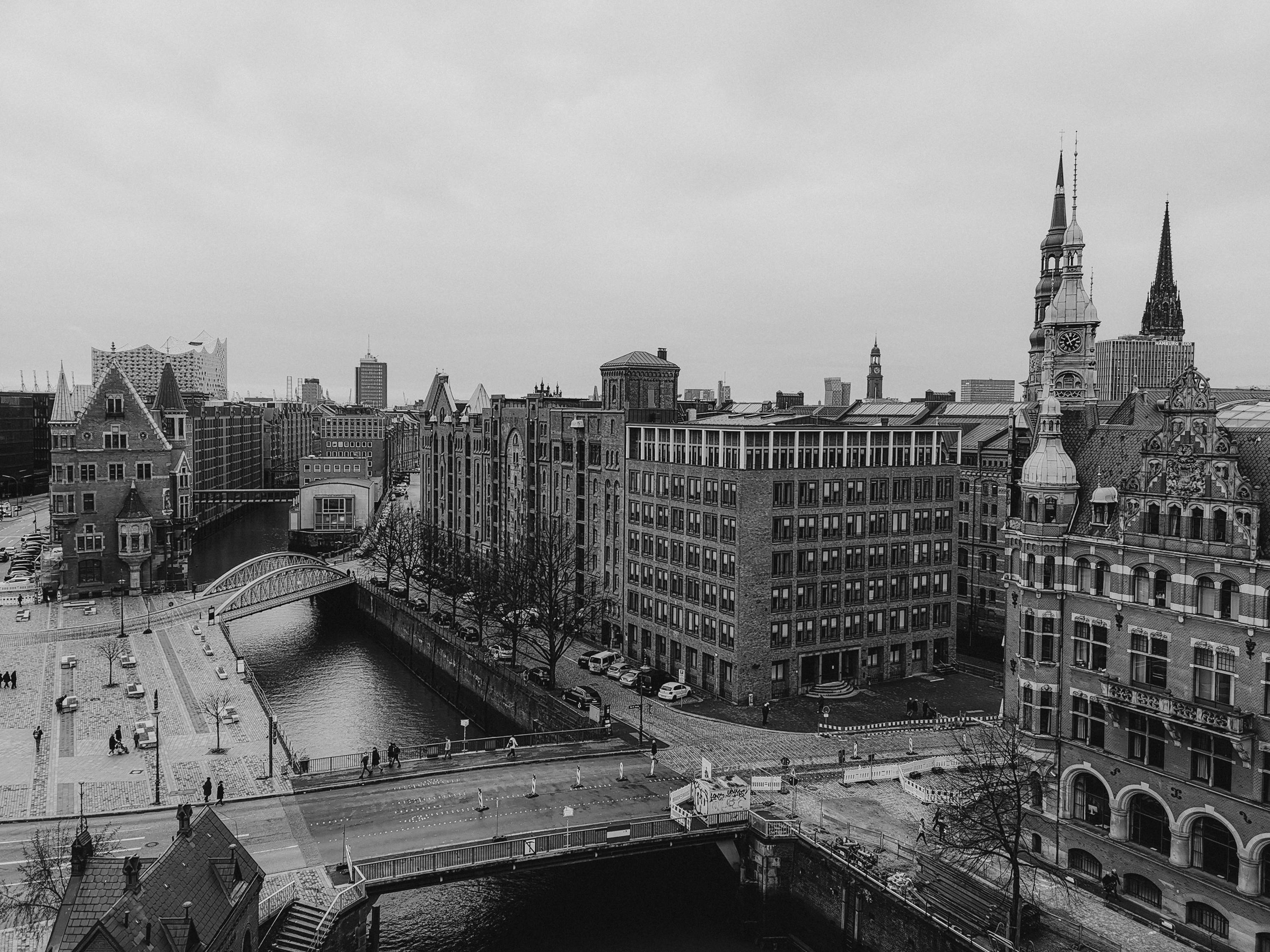 A black and white aerial view of a historic European city with canals and classic architecture.