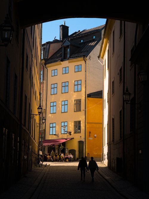 Free Beautiful sunlit street in Gamla Stan, Stockholm, showcasing classic architecture and vibrant scenes. Stock Photo