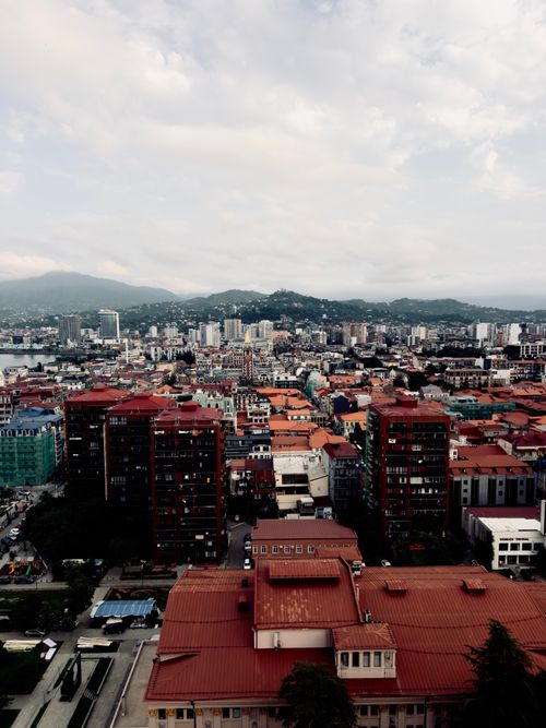 Free A high angle view of a vibrant city with red roof buildings under a cloudy sky. Stock Photo