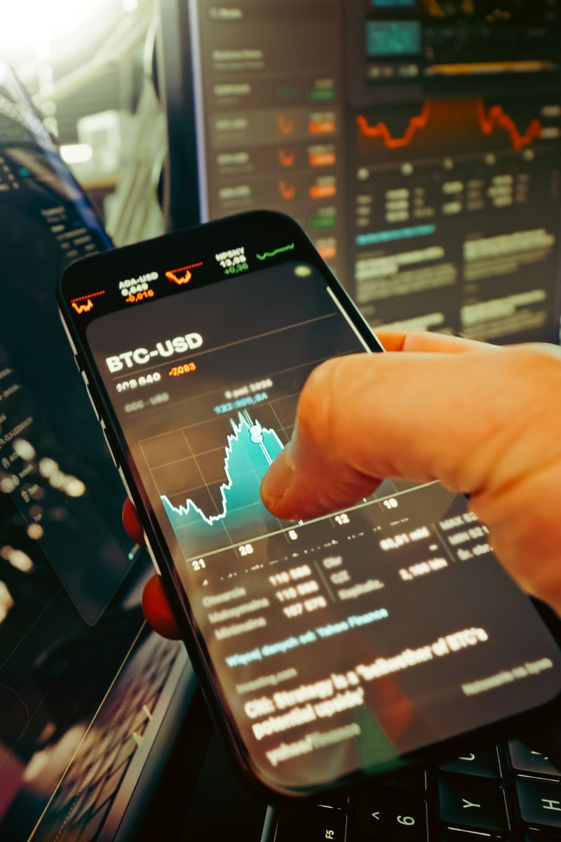 A marketer reviewing colorful app analytics charts on a laptop and smartphone side by side on a modern desk