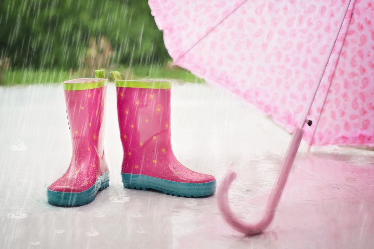 pink polka-dot rain boots with an umbrella in the rain