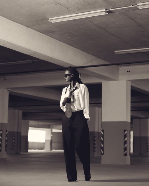 Free Fashionable adult woman with tie in urban parking garage, sepia tone. Stock Photo