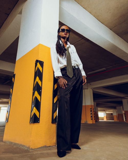 Free Stylish woman in chic outfit posing confidently in a modern parking garage. Stock Photo