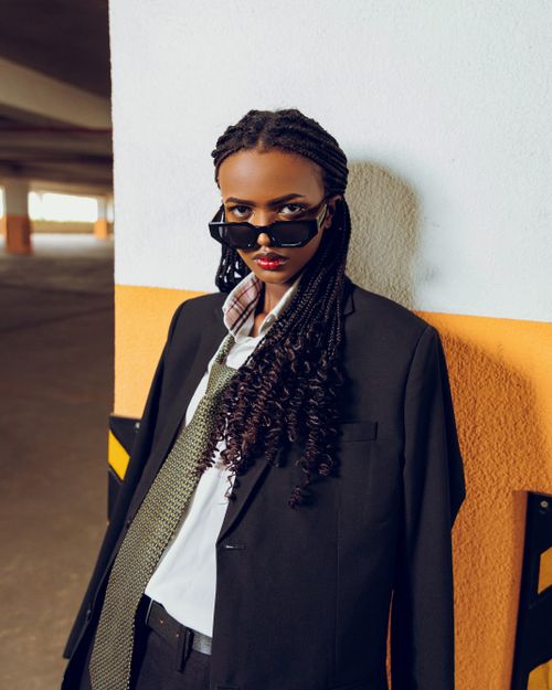 Free Confident woman in sunglasses and business suit standing against wall. Stock Photo