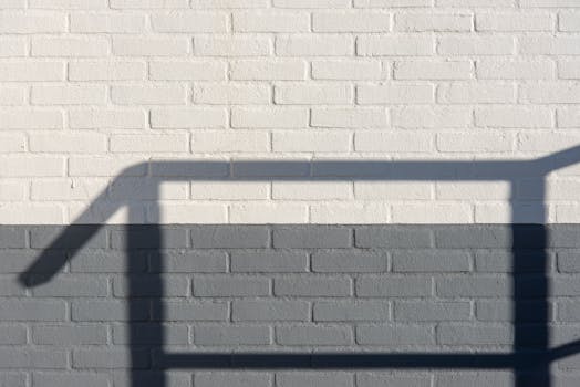 A minimalist composition of a brick wall showcasing shadows on its surface.