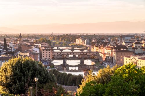 Free Breathtaking sunset view of Florence, Italy, showcasing the Arno River and historic architecture. Stock Photo