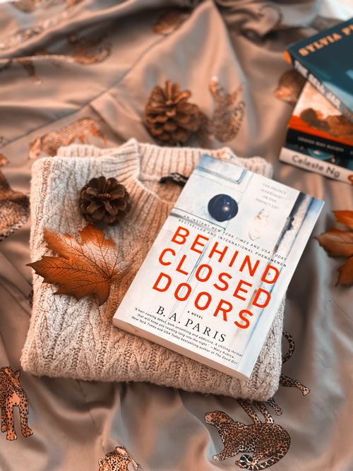 Free Autumn-inspired flat lay featuring a book, sweater, and fall leaves for a cozy aesthetic. Stock Photo