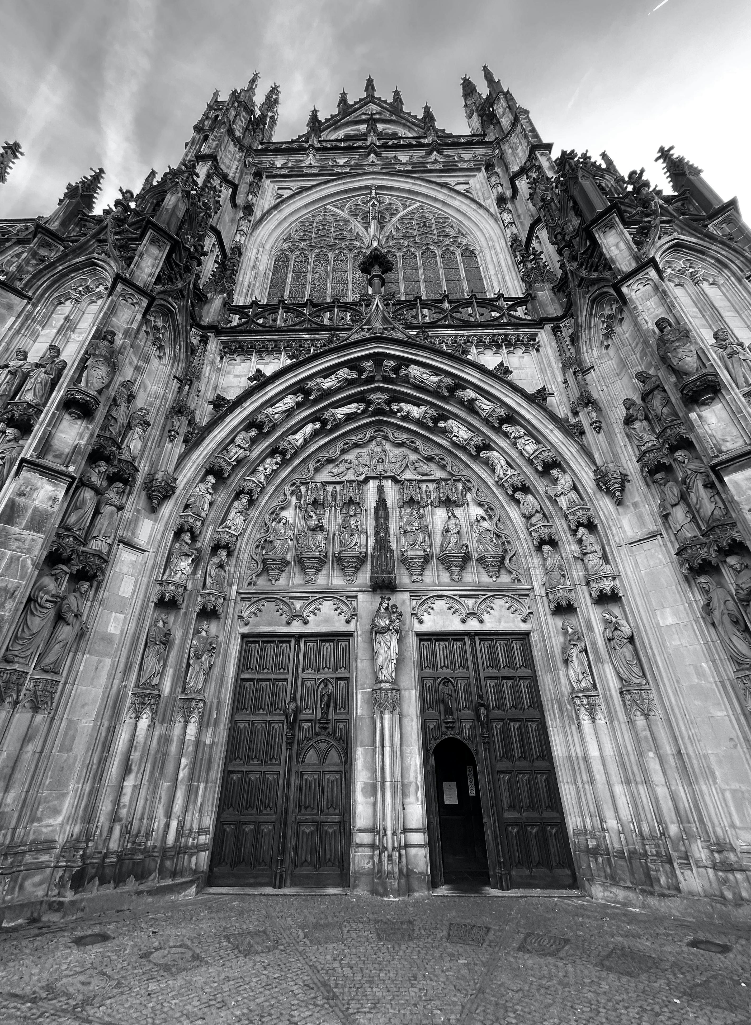 Black and white image of a gothic cathedral entrance in 's-Hertogenbosch, Netherlands.