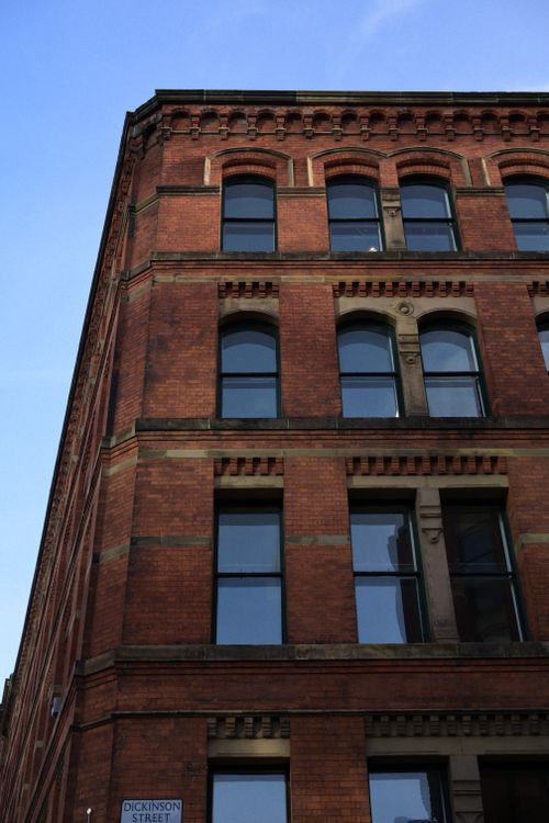 Free Angled view of a historic red brick building on Dickinson Street against a blue sky. Stock Photo