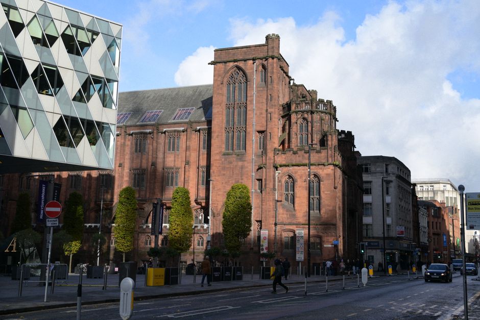 Contrast of modern and Gothic architecture on a sunny urban street.