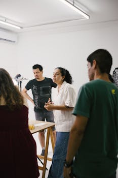 A group of adults engaged in lively discussion in a bright indoor studio environment.