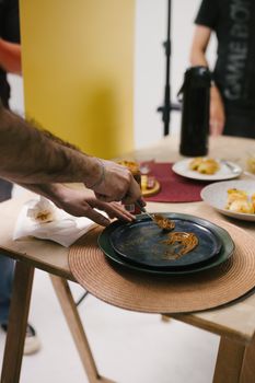 Chef preparing a Brazilian dish in a professional kitchen with various ingredients.