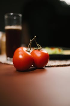 Fresh red tomatoes placed on a table with a blurred background, focusing on vibrant produce.