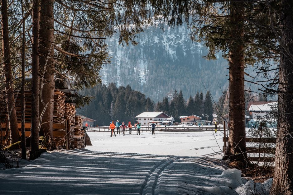 Cross-country skiing in snowy Leutasch, Austria, framed by tall trees and charming chalets.