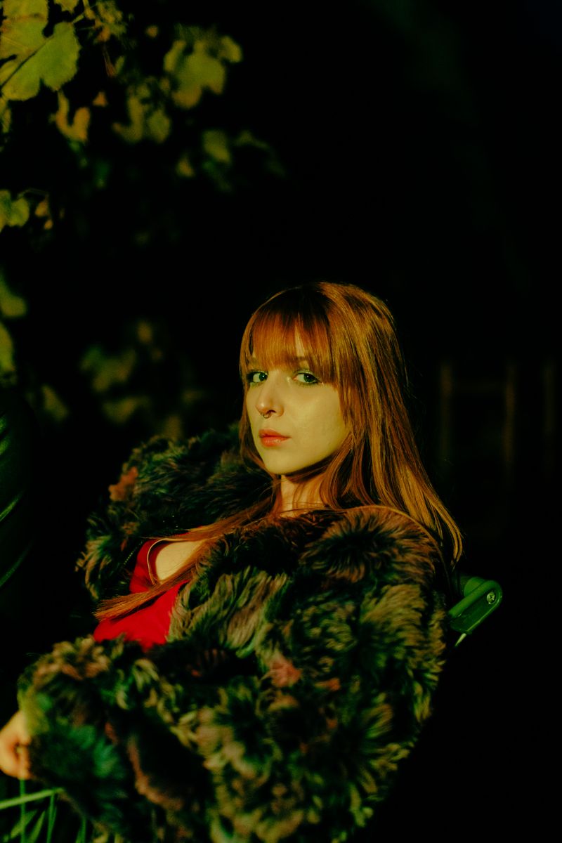 Woman in fur coat outdoors at night