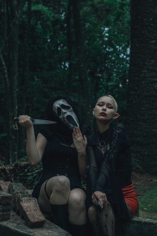 Free Dark and mysterious scene with two costumed figures in a forest setting. Stock Photo