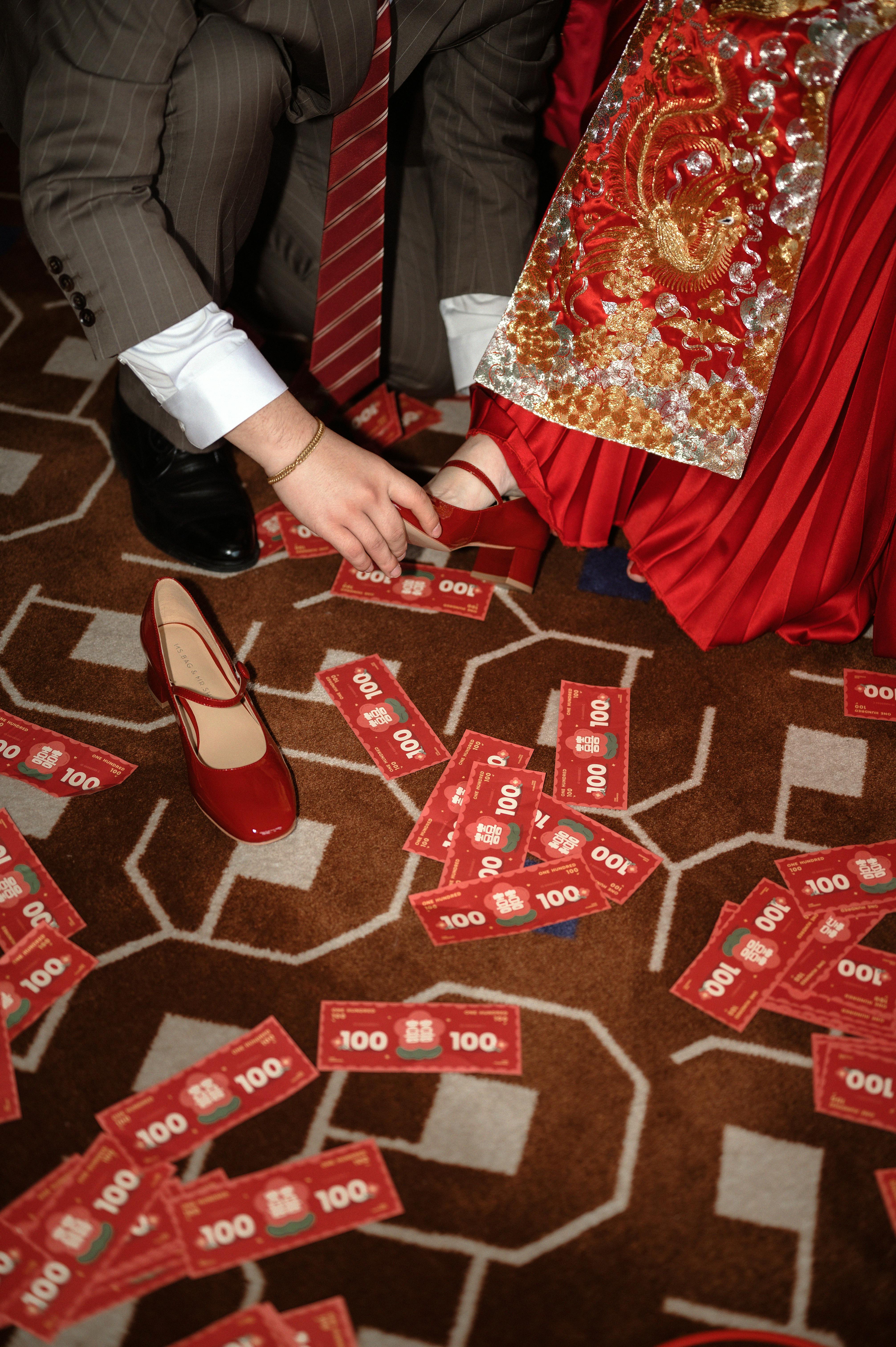 Traditional wedding ceremony with scattered red envelopes symbolizing prosperity and luck.