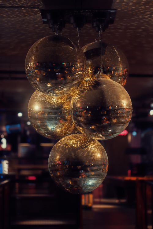 Free A collection of reflective disco balls hanging from the ceiling, creating a festive atmosphere in a dimly lit nightclub. Stock Photo