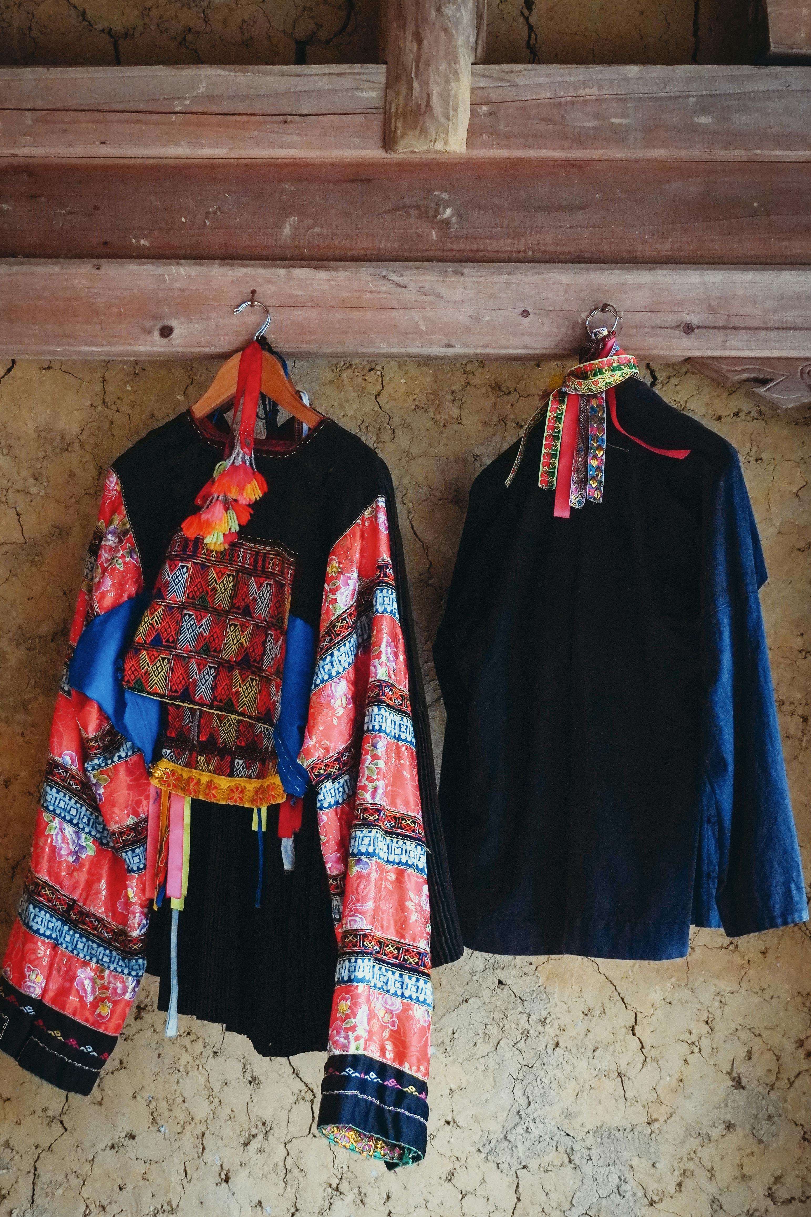 Vibrant traditional clothes hanging on a rustic wall, showcasing cultural fashion.