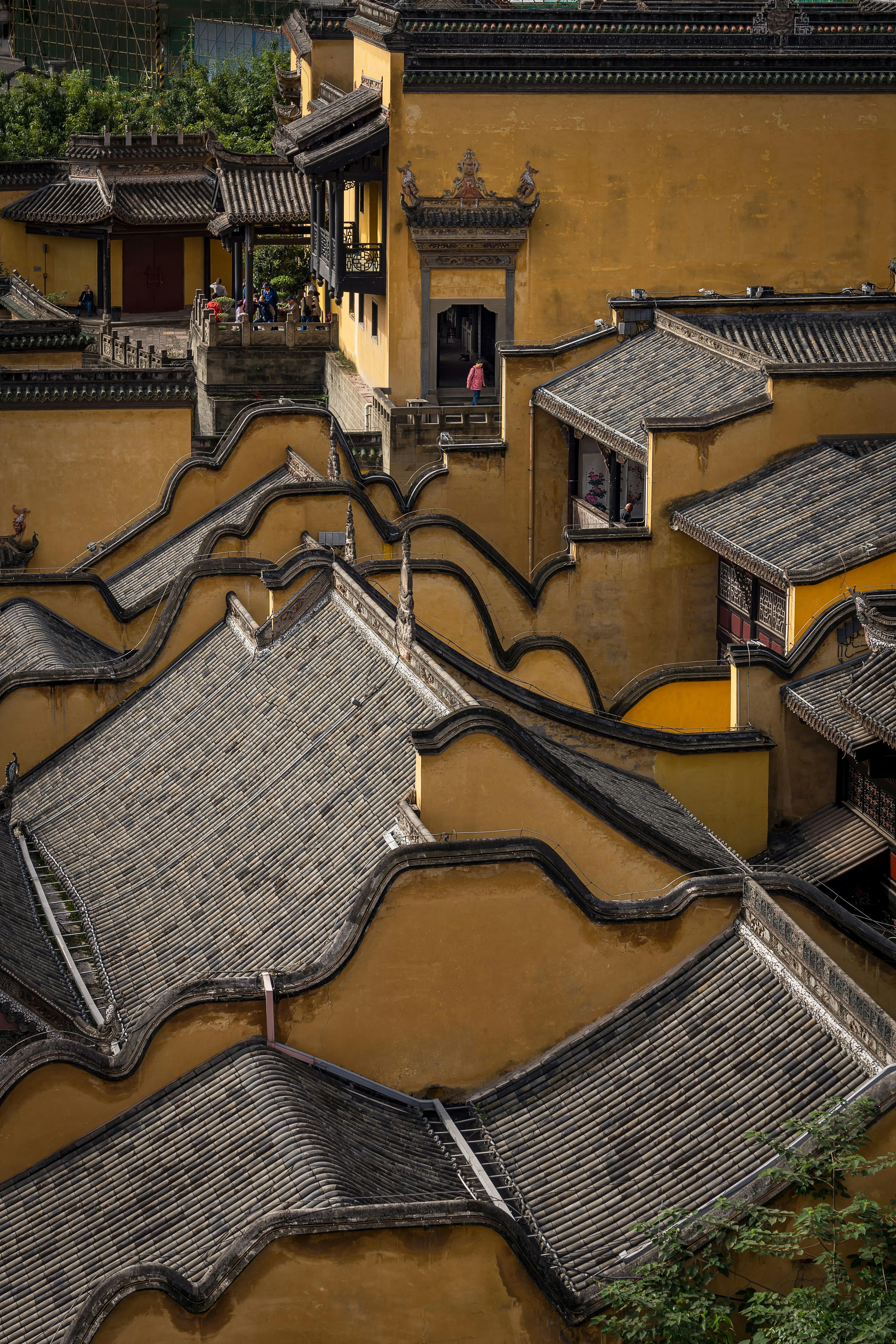 Detailed view of traditional Chinese rooftops with intricate patterns and vibrant golden walls.