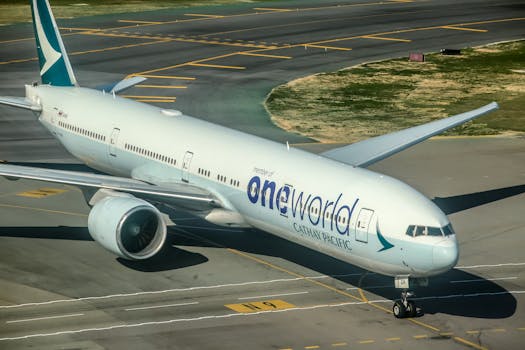 Aereo Boeing della Cathay Pacific in fase di rullaggio sulla pista, con il logo dell'alleanza oneworld esposto.