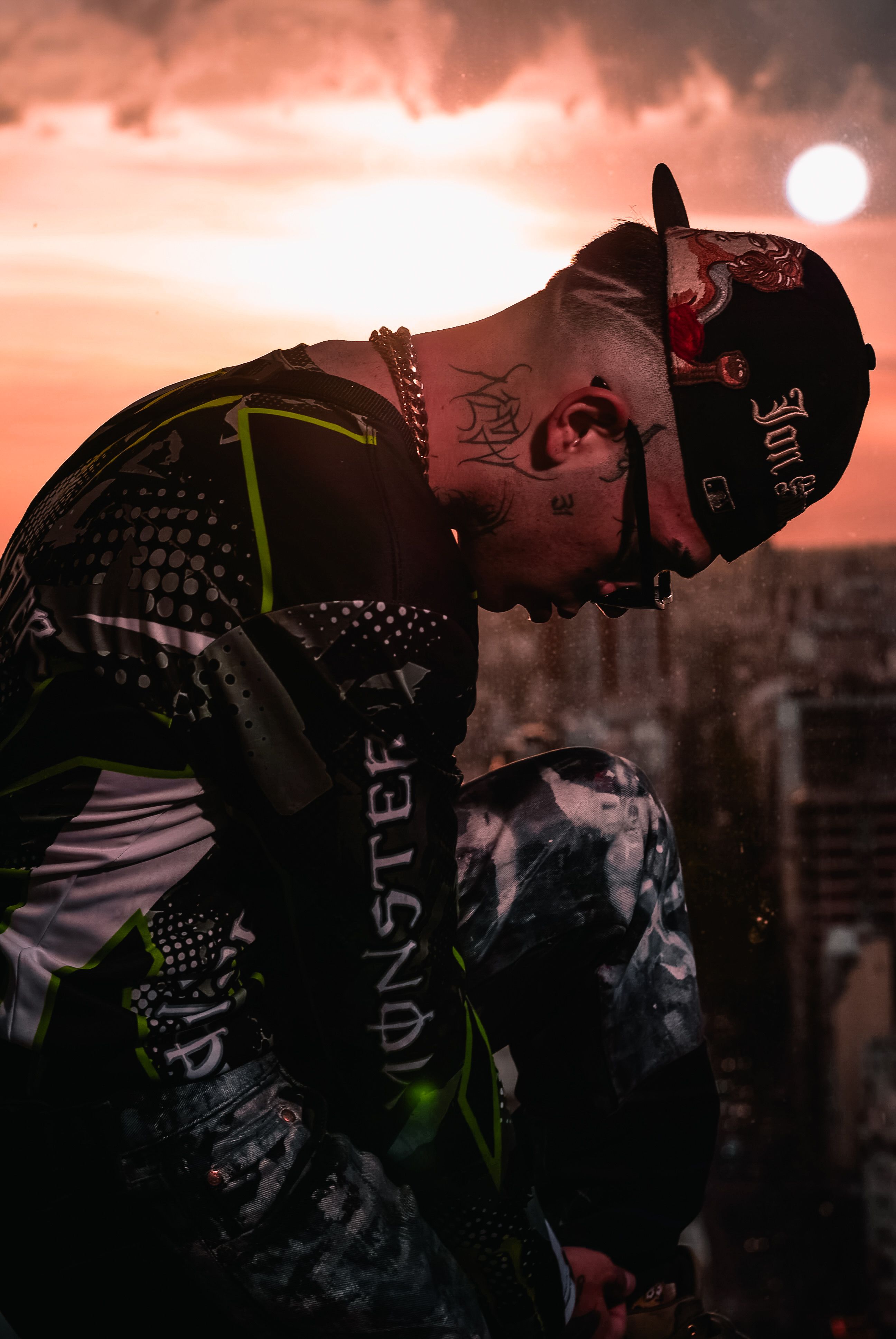 Contemplative young adult on a rooftop with a stunning sunset view of Buenos Aires, Argentina.