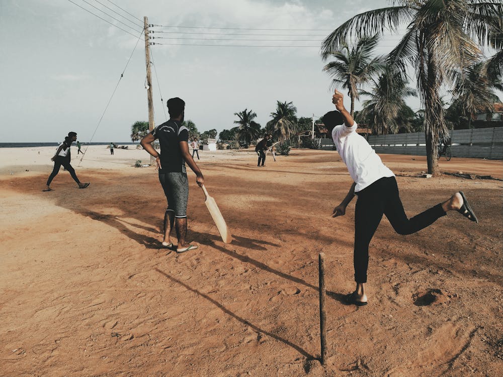 Men Playing Cricket at Beach