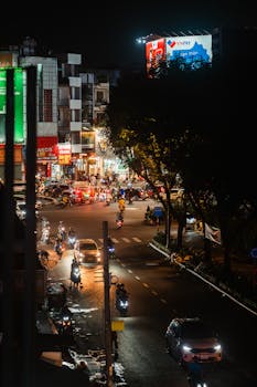 Busy urban street at night with lively traffic and illuminated city lights in Vietnam.