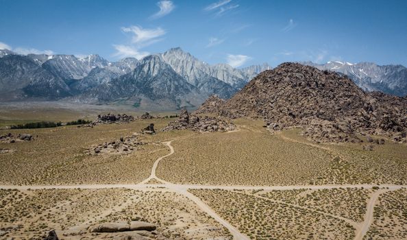 Stunning aerial capture of Alabama Hills with rugged Sierra Nevada backdrop under clear blue sky.