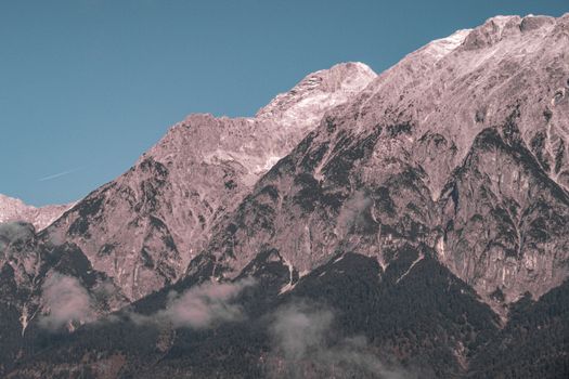 Breathtaking view of the Alpine mountains under a clear blue sky, showcasing rugged peaks.