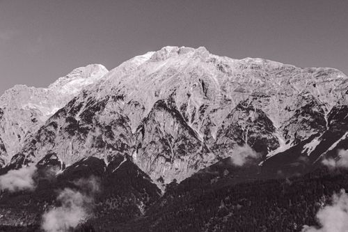 Free A striking black and white image of the majestic Alps mountains with a dramatic sky. Stock Photo