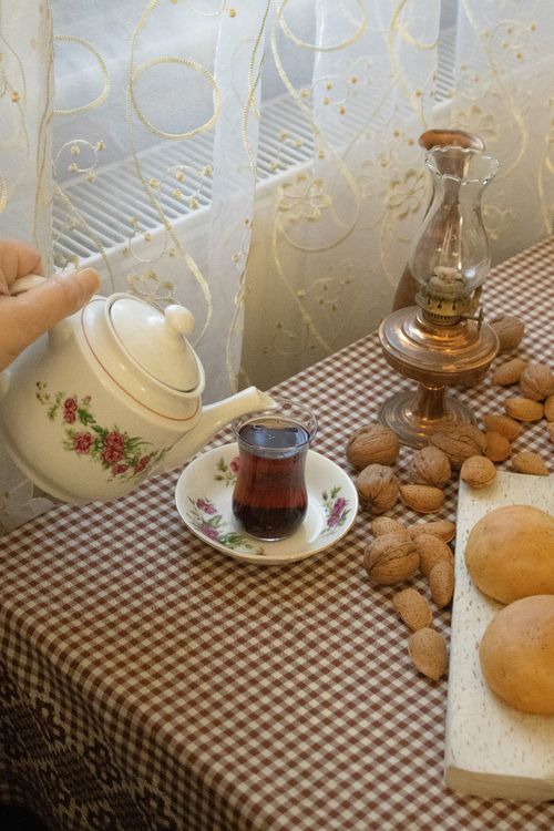 Free Warm indoor scene with tea, nuts, and bread on a checkered tablecloth; a perfect cozy setup. Stock Photo
