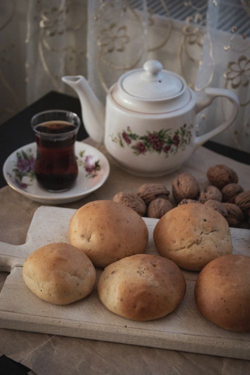Free A cozy indoor scene with tea, freshly baked rolls, and walnuts, perfect for a traditional snack. Stock Photo