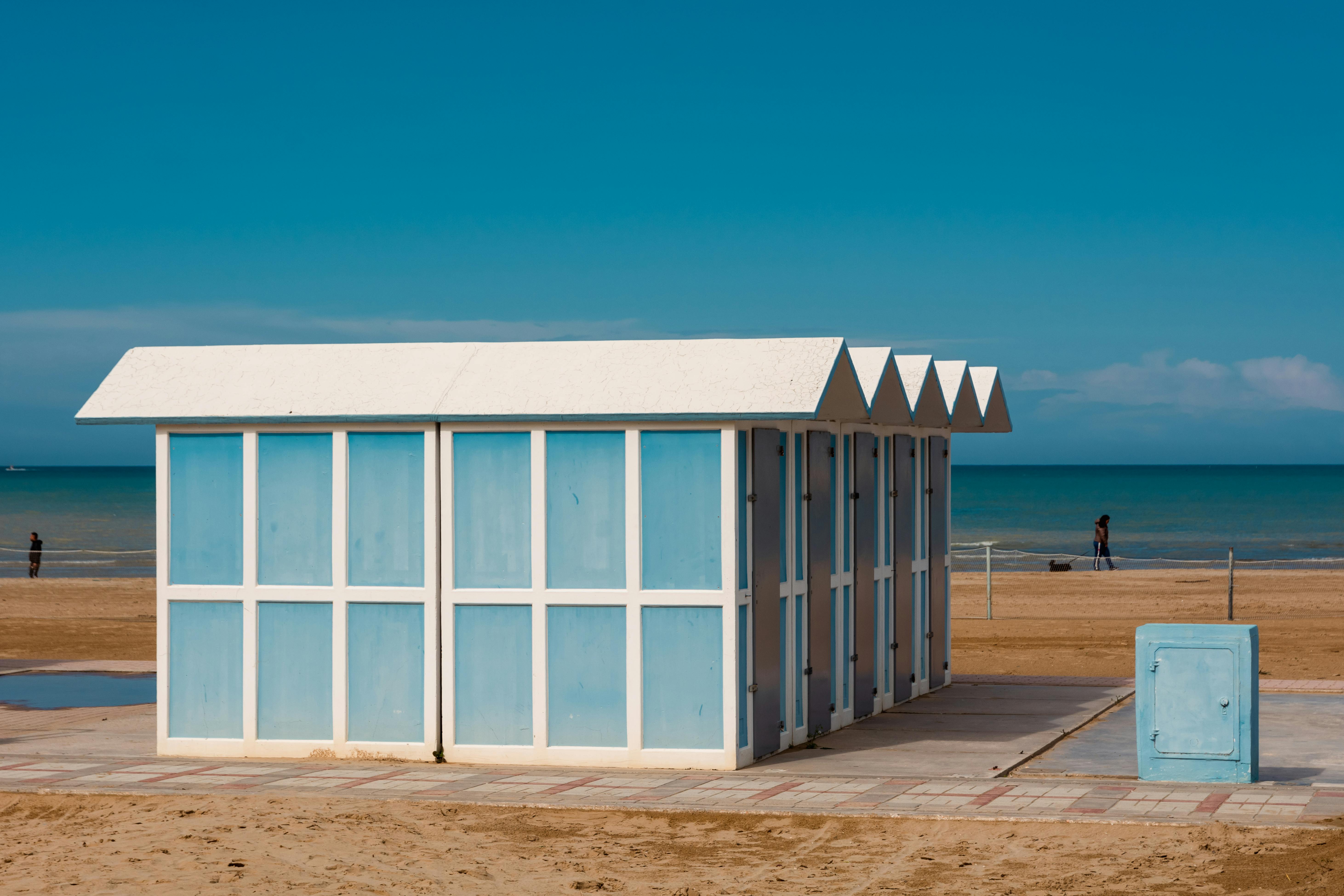Seaside beach cabins with clear blue sky, perfect summer escape.