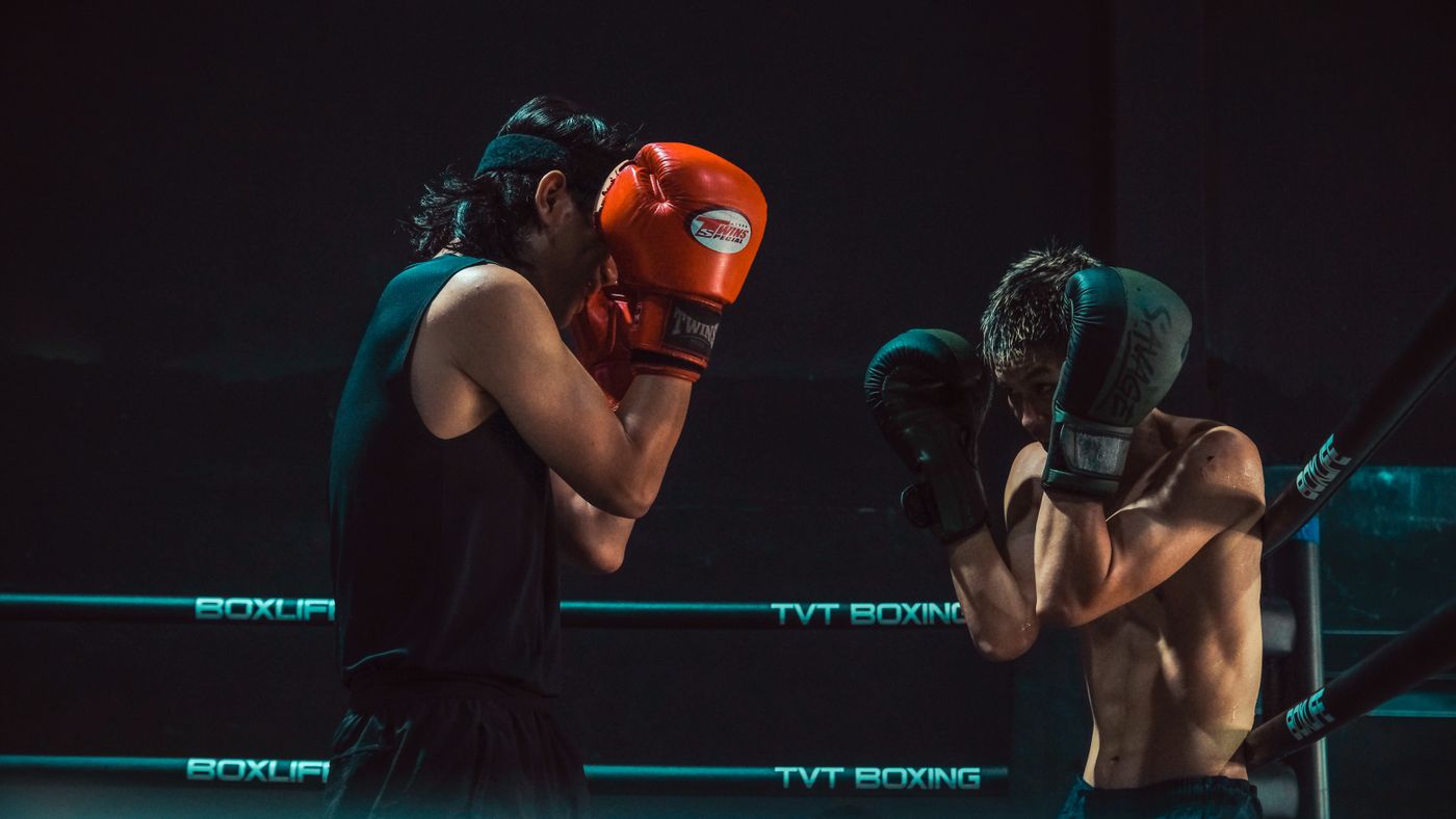 Two fighters sparring in a boxing ring during a live combat sports broadcast