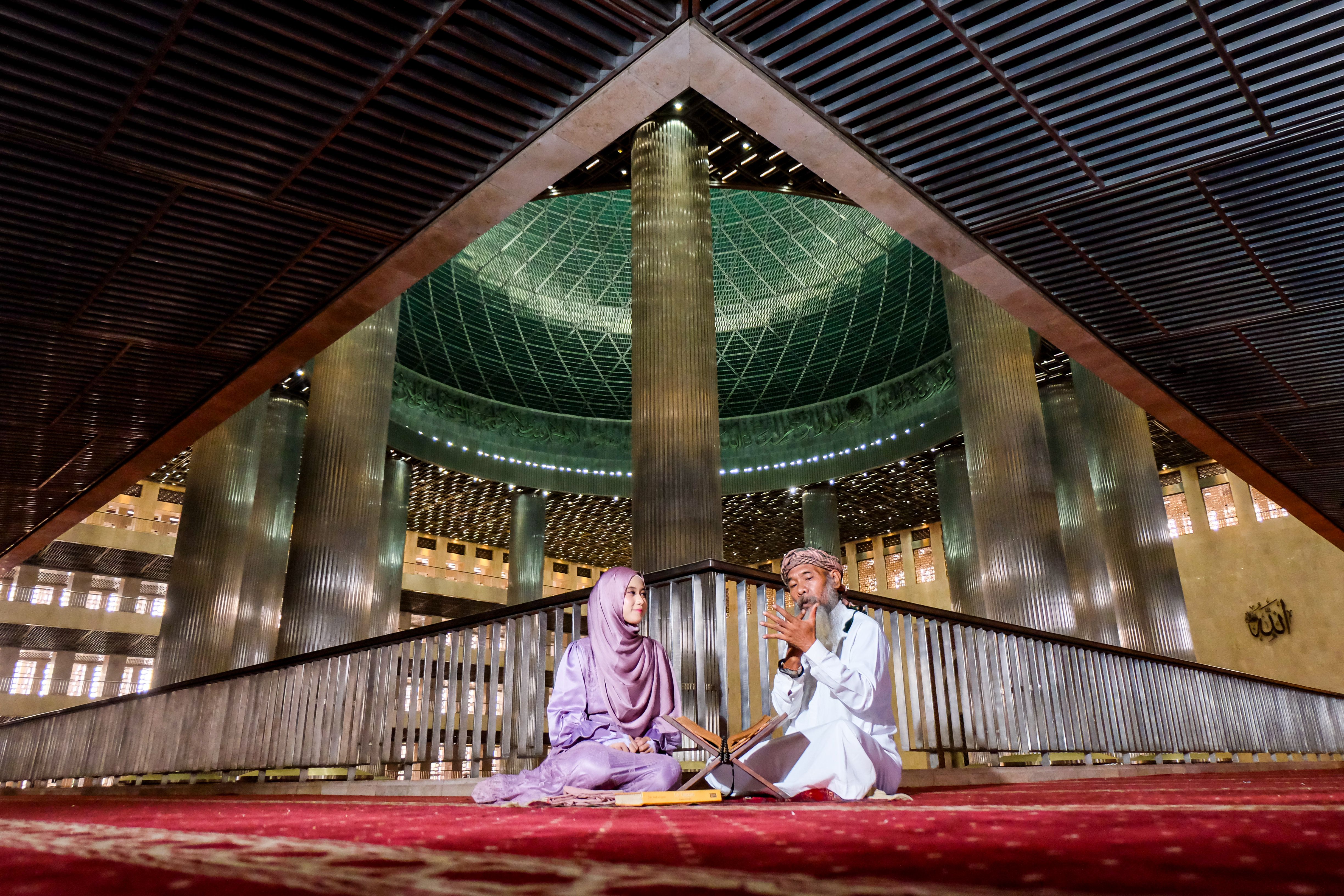 Two People Sitting Inside Grand Mosque Interior · Free Stock Photo