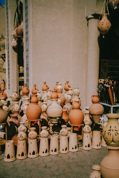 Artisan clay pots and lanterns displayed in a bustling Moroccan market, capturing cultural craftsmanship.