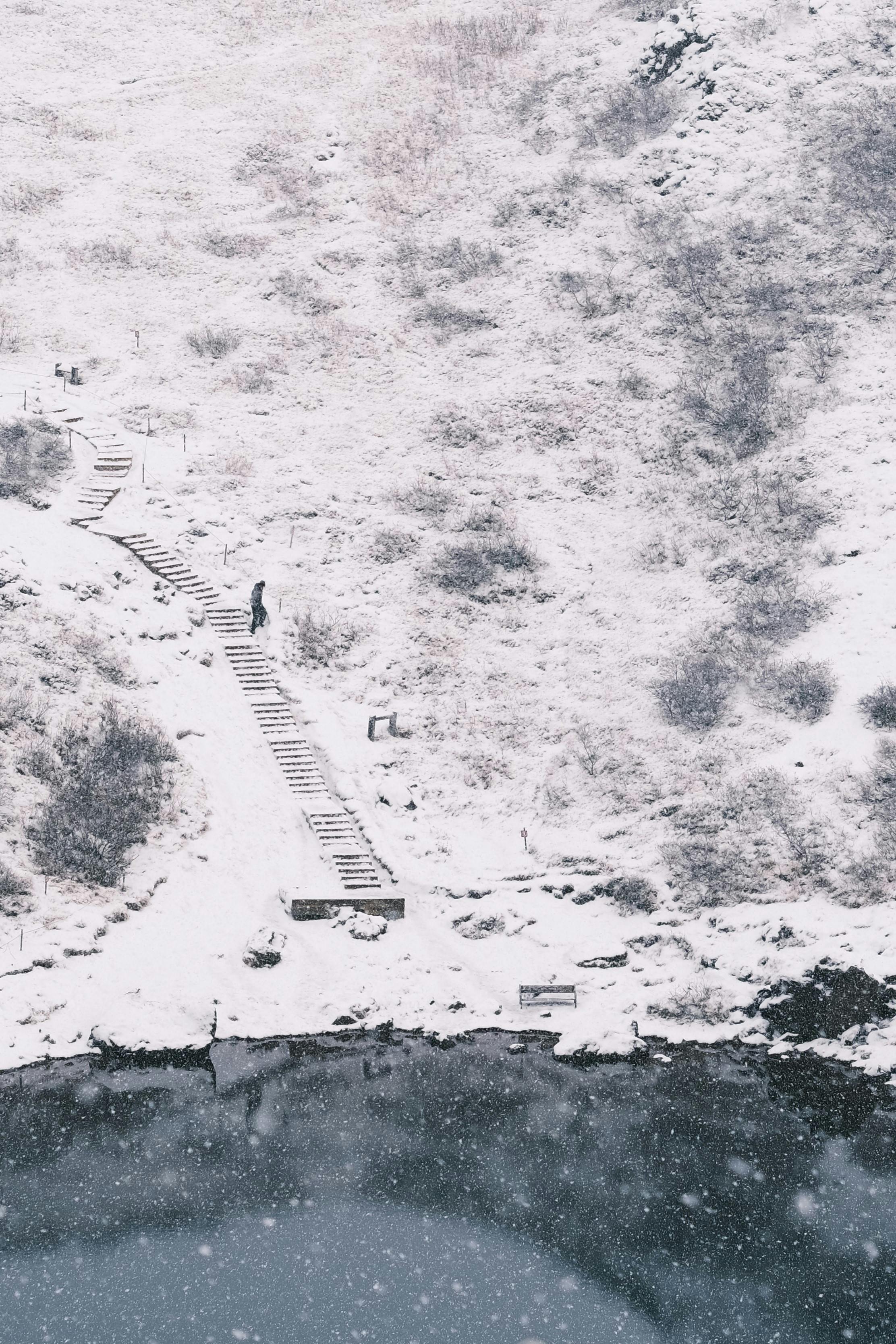 gratis Een sereen wintertafereel van een met sneeuw bedekt pad in de buurt van een kratermeer in IJsland. Stockfoto