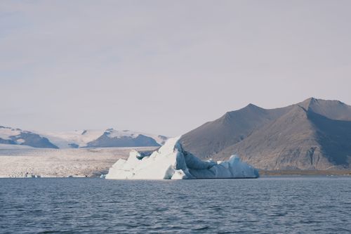 Free Serene view of an iceberg with distant mountains in Icelandic landscape. Stock Photo
