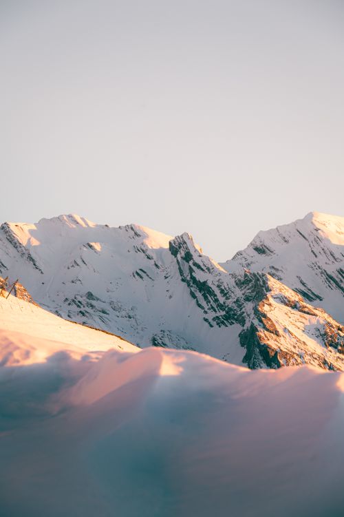 Free Serene winter landscape of snow-covered peaks at sunset in Le Grand-Bornand, France. Stock Photo