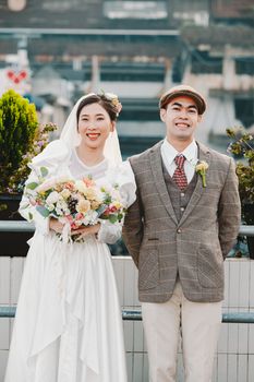 Charming outdoor portrait of a joyful couple on their wedding day, embracing love and celebration.