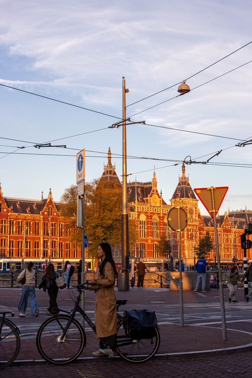 Free A picturesque evening scene in Amsterdam showcasing cycling culture with historic architecture in the background. Stock Photo